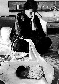 Shortages of food and medicine have caused the death of many children. Mother with dead child in Mansour Pediatric Hospital, Baghdad, Iraq (Bill Hackwell ) 